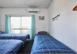 2 Betten in einem Zimmer mit Fenster in der Unterkunft 2BR 5beds Shibuya Shinjuku Harajuku 10min wifi in Tokio