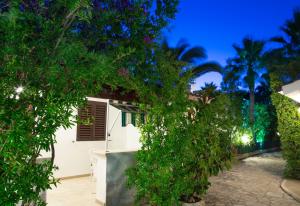 una casa bianca con alberi e piante di notte di Residence La Conchiglia a Vieste