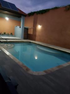 a large blue swimming pool in front of a house at Maison Romantique in Kingston