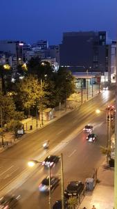 una calle de la ciudad por la noche con coches en la carretera en City Lights Athens en Athens