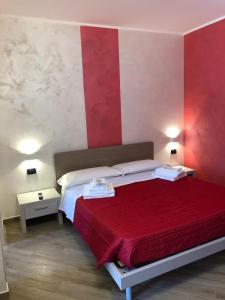 a bedroom with a bed with a red and white wall at Residence La Marinella in Palmi