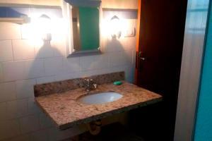 een badkamer met een wastafel en een spiegel bij Quinta dos Paiva: horta natural e sossego in Monte Alegre do Sul
