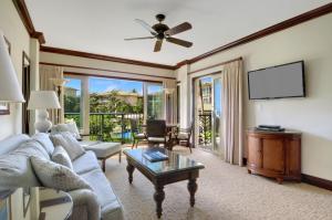 a living room with a couch and a tv at Waipouli Beach Resort Gorgeous Luxury Ocean View Condo! Sleeps 8! in Kapaa