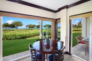 a dining room with a table and a view of the ocean at Waipouil Beach Resort Gorgeous Ocean Front Condo! Sleeps 8 AC Pool in Kapaa