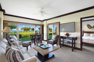 a living room with a couch and a tv at Waipouil Beach Resort Gorgeous Ocean Front Condo! Sleeps 8 AC Pool in Kapaa