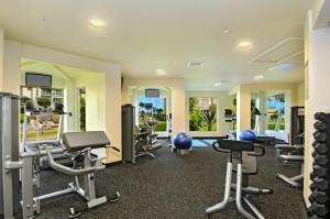 a gym with several treadmills and exercise equipment at Waipouli Beach Resort Penthouse Exquisite Ocean & Pool View Condo! in Kapaa