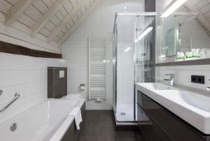 ein Bad mit einer Badewanne, einem Waschbecken und einer Dusche in der Unterkunft Winselerhof - Oostwegel Collection in Landgraaf