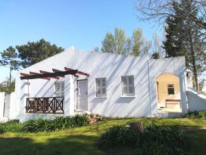 una casa blanca con techo de gambrel en Zevenwacht Cottages, en Kuilsrivier