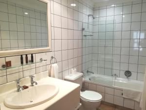 Un baño con lavabo, inodoro y bañera. en Zevenwacht Cottages, en Kuilsrivier 21 fotos más