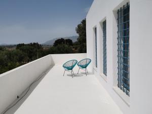 duas cadeiras sentadas na varanda de uma casa em casa zabbara em Balestrate