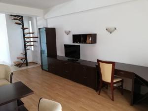 un soggiorno con scrivania, TV e sedia di Casa Ruxandrei a Constanţa