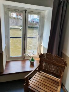 a wooden bench in front of a window at Canalview Hotel Ter Reien in Bruges
