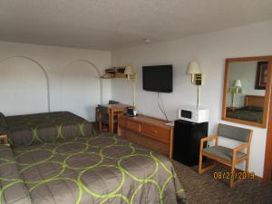 Habitación de hotel con cama y TV en North Country Inn & Suites en Mandan