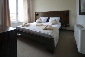 Gold Club Hotel & Casino في آيدوشتشينا: غرفة نوم عليها سرير وفوط