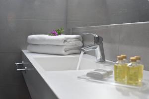lavamanos con toallas y grifo en Nissi Beach Resort, en Ayia Napa