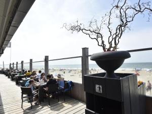 a restaurant on the beach with people sitting at tables at Cosy Petten, Family only in Petten