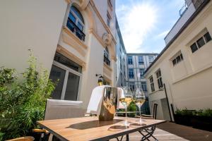 a table with two glasses of wine on a balcony at Continental Hotel in Reims
