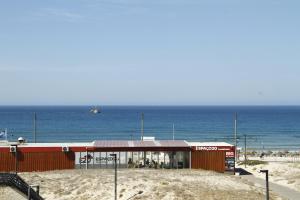 a building on the beach next to the ocean at Caparica Sea View Apt by be@home in Costa da Caparica