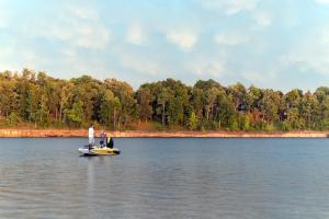 a man standing on a small boat on a lake at Rough River Dam State Resort Park in Fentress McMahan