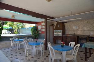 un restaurante con mesas azules y sillas blancas en Pousada Recanto de Minas, en Porto Seguro