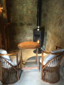 a wooden table and two chairs and a stove at Casetta in Olivese