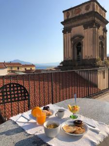 a table with plates of food on a balcony at Hotel Rivoli Sorrento in Sorrento