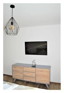 a living room with a tv on a white wall at SGL apartments Lavickova in Trenčín
