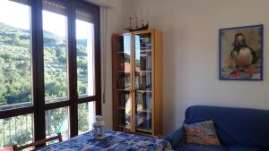 a living room with a book shelf and a blue couch at Casetta al Mare in Giustenice