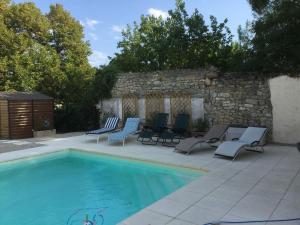 Moulézan的住宿－Maison de maître cévenol，一个带躺椅和石墙的游泳池