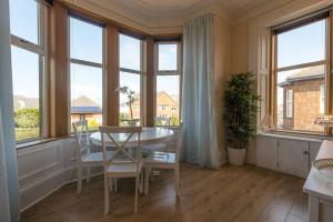 a dining room with a table and some windows at Arran View in Prestwick