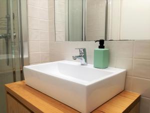 - un lavabo blanc dans la salle de bains avec un distributeur de savon dans l'établissement Own Places Relax Porto Studio, à Porto