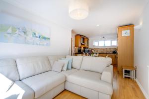 a living room with a white couch and a kitchen at Beach Retreat Broadstairs in Broadstairs