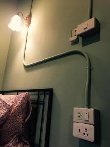 una luz en una pared junto a una cama y un espejo en Talardkao Balcony Krabi, en Krabi