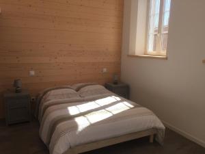 a bedroom with a bed with a wooden wall at La rose trémière in Rivedoux-Plage