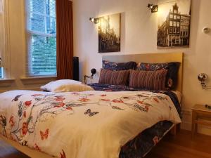 sypialnia z łóżkiem z kołdrą kwiatową w obiekcie Huis Roomolen w Amsterdamie