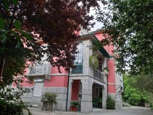 een roze en wit huis met een balkon bij Casa Da Espinhosa in Guimarães