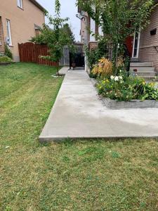 a sidewalk in a yard next to a house at Clean, Beautiful & Modern 2 bedroom apartment in Mississauga