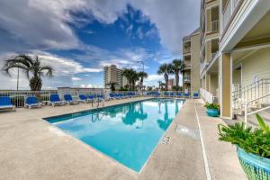 a swimming pool at a resort with blue chairs at Grande Caribbean in Orange Beach