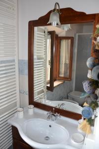 a bathroom with a sink and a mirror and a tub at Agriturismo Villa Rosetta in San Severino Marche