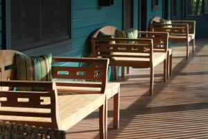 une rangée de bancs assis à l'extérieur d'un bâtiment dans l'établissement Lumeria Maui, Educational Retreat Center, à Makawao