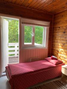 a bed in a room with two windows at Tooraku Turismitalu in Pusku