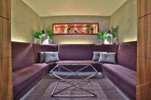a living room with a purple couch and a table at Botanique Hotel Prague in Prague