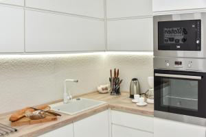 a kitchen with a sink and a microwave at Lux Apartment Flatiron Skopje in Skopje
