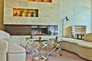 a living room with a couch and a fireplace at Botanique Hotel Prague in Prague