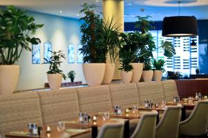 a dining room with tables and potted plants at Botanique Hotel Prague in Prague