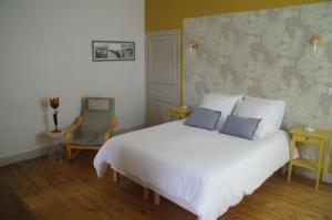 una camera da letto con un letto bianco con due cuscini sopra di Maison Latour a Cholet