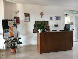 a reception desk in a church with a cross on the wall at Casa Mater Ecclesiae in Massa Marittima