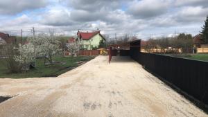 een onverharde weg met een hek voor een huis bij Vila Ekooos in Braşov