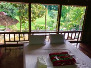 Cette chambre comprend un lit blanc et une grande fenêtre. dans l'établissement VuLinh Family Homestay, à Yên Bình