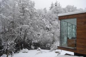 a cabin in the snow with trees in the background at Alesga Hotel Rural - Valles del Oso -Asturias in San Salvador